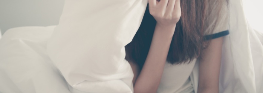 Girl with long hair hiding behind big white blanket